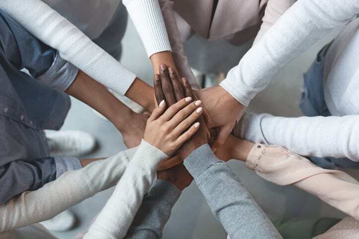 Business Team Putting Hands Together On Top Of Each Other 1201215883 727x484